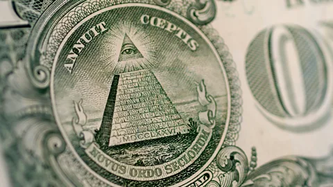 A gold emblem representing the illuminati symbol and the concept of global personal advancement.