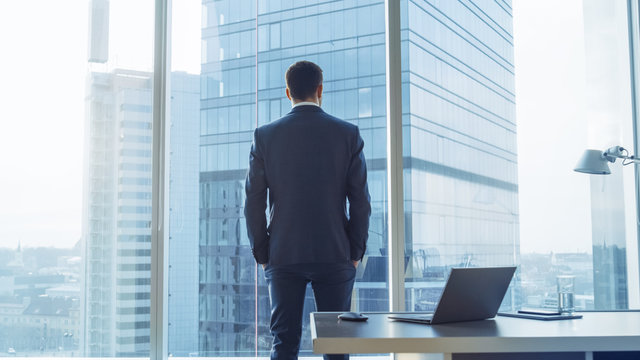 A person looking out over a city, symbolizing the achievement and personal advancement sought by members of the Illuminati Brotherhood.