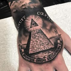 Person looking at their illuminati tattoo featuring pyramid artwork