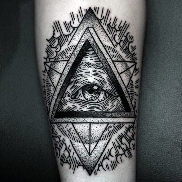 A detailed black and gold illuminati tattoo featuring an eye design anA detailed black and gold illuminati tattoo featuring an eye design and pyramid artwork on a forearm.d pyramid artwork on a forearm.